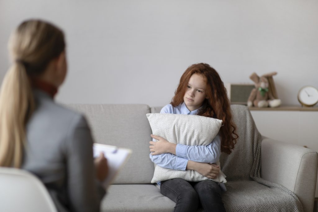 A psychiatrist talks with a depressed teen girl