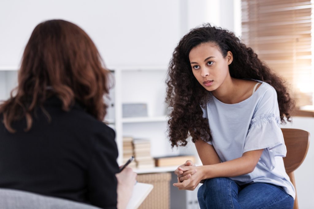 Professional counselor and woman suffering from depression during therapy