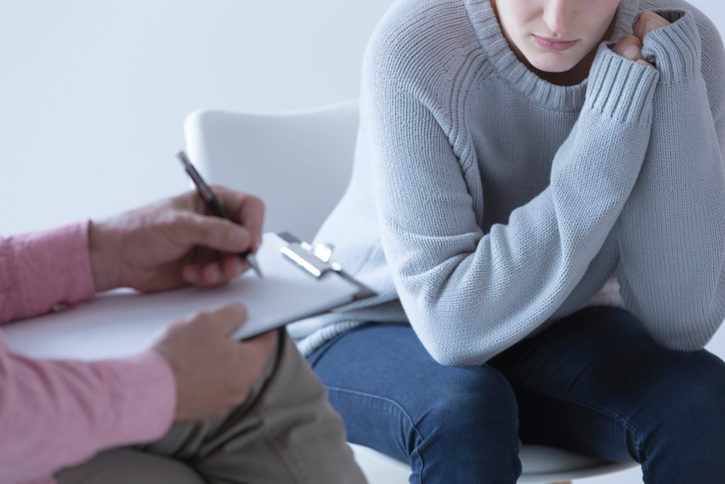 Young woman with depression sees her psychotherapist