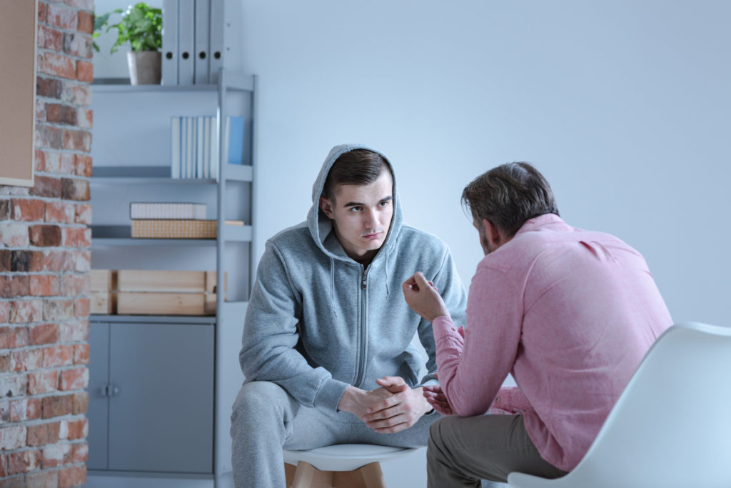 A young adult male with depression talks with his psychiatrist
